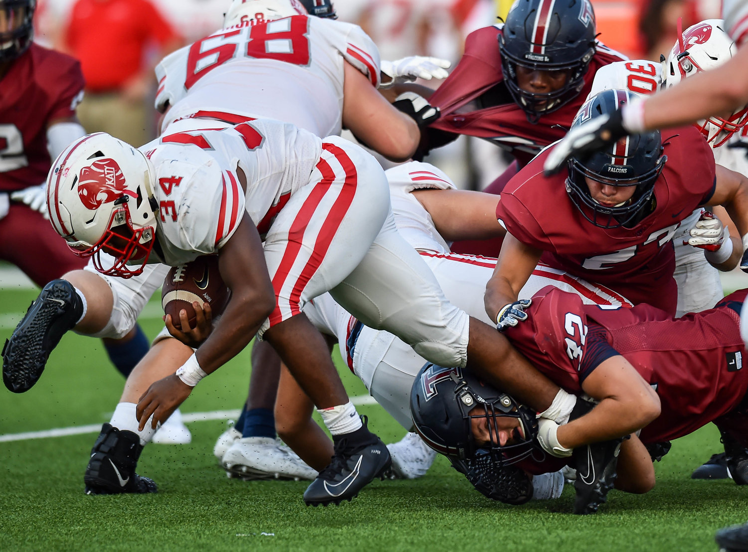 Katy, Tx. Oct. 3, 2019: Katy's Ronald Hoff (34) carries the ball getting tripped up by Tompkins Bryce Shaink (32) during a game between Katy Tigers and Tompkins Falcons at Legacy Stadium in Katy. (Photo by Mark Goodman / Katy Times)
